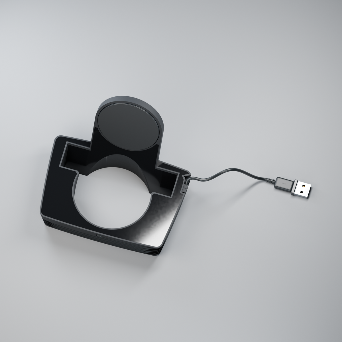 Puck Cup from above, showing the drink opening, black acrylic, upright charging puck, cable and USB-A plug.